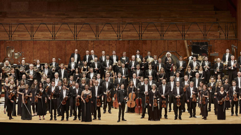 Das Orchester der Staatsoper Stuttgart, stehend auf einer Bühne